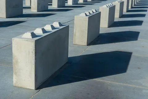 Artistically arranged concrete blocks casting shadows on the ground.