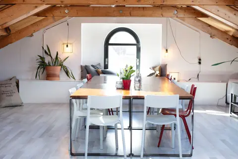 Stylish loft conference room with natural light and wooden beams.
