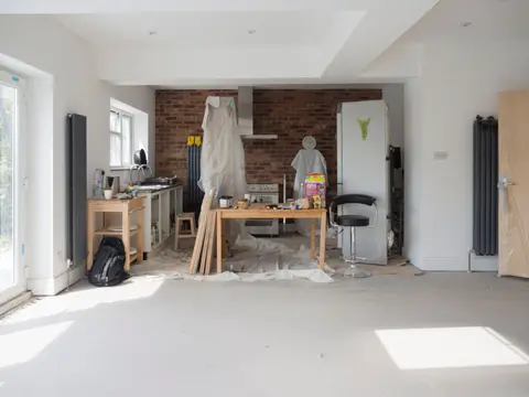 Bright kitchen extension showing renovation work with tools and materials.