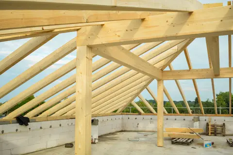 Close-up of graded structural timber trusses and joists in an unfinished roof.