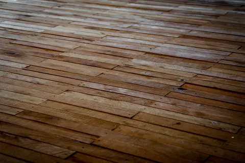 Detailed view of rustic wooden floor with staggered planks showcasing natural texture.