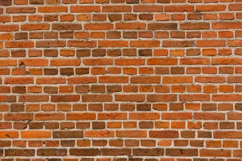Close-up view of a classic red brick wall creating a textured pattern.